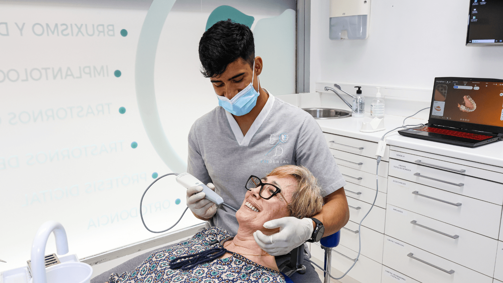 Odontólogo de EVIDENTAL realizando una valoración dental a una paciente durante la primera visita en Sarrià (Barcelona).